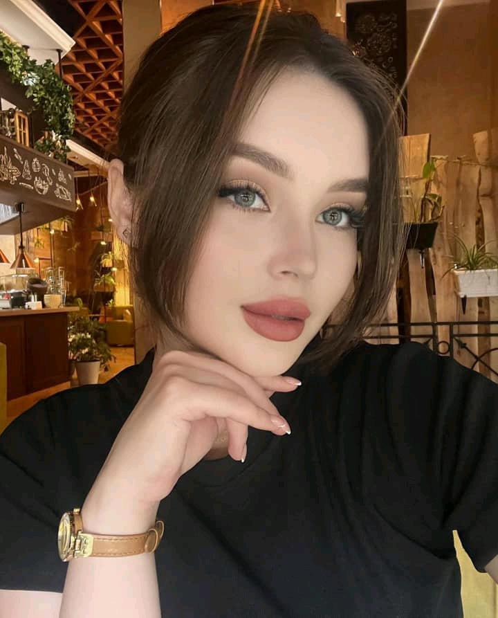 naey looking toward the camera in a café